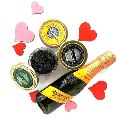 Bottle of Mionetto Prosecco with caviar tins and heart-shaped decorations on a white background